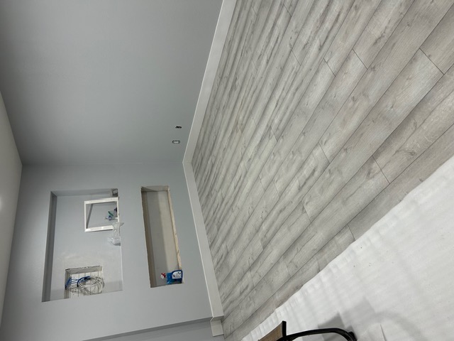 Light gray wood-look flooring in a finished Las Vegas room with a wall niche