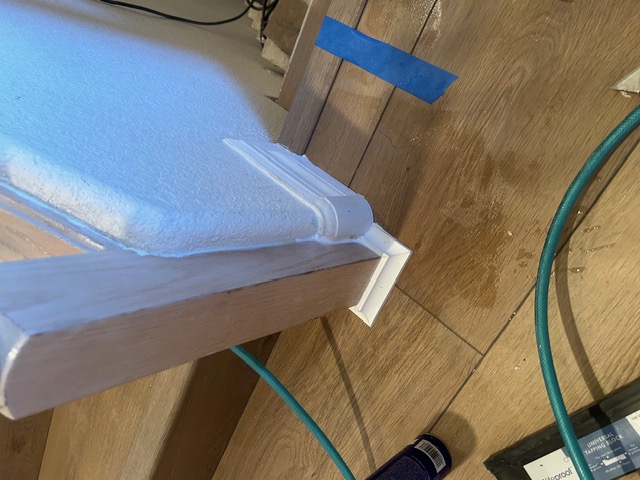 Freshly installed white baseboard and trim along a new wood floor in Las Vegas