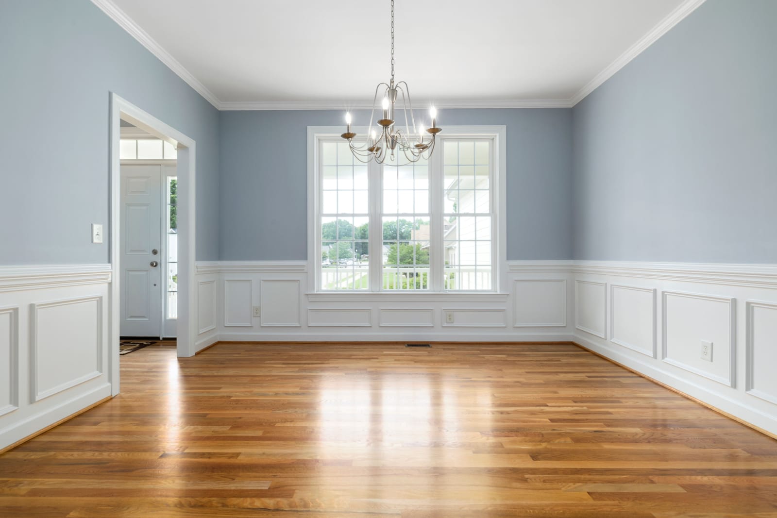 Finished Las Vegas dining room with crown molding, wainscoting, and wood flooring