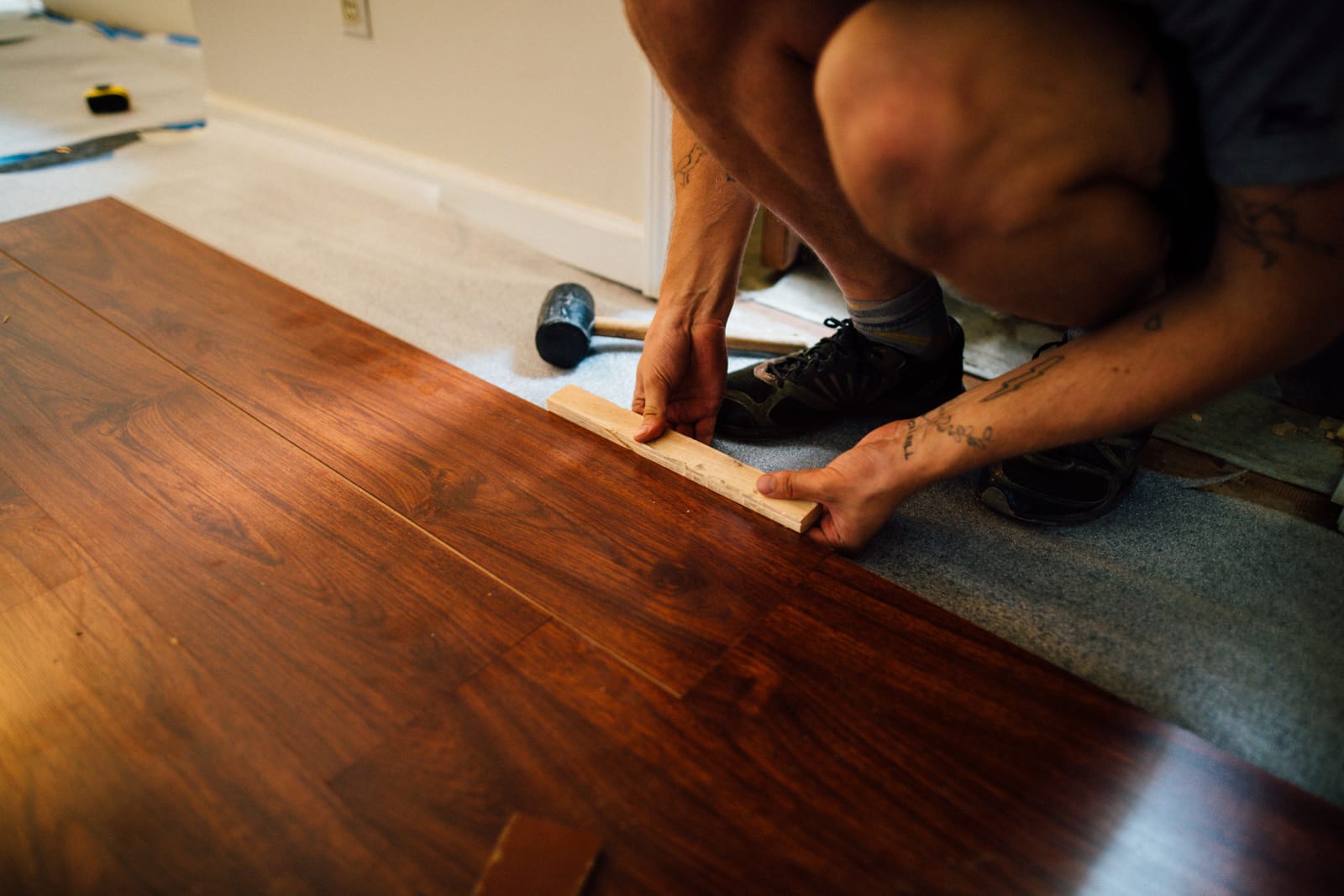 Installer fitting new hardwood plank flooring during a Las Vegas floor removal and replacement