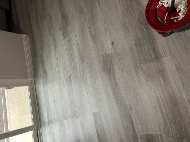Gray luxury vinyl plank flooring beside a sliding glass door in a Las Vegas home