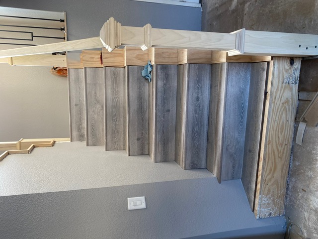 Finished gray wood stair treads and risers with a wood newel post in a Las Vegas home