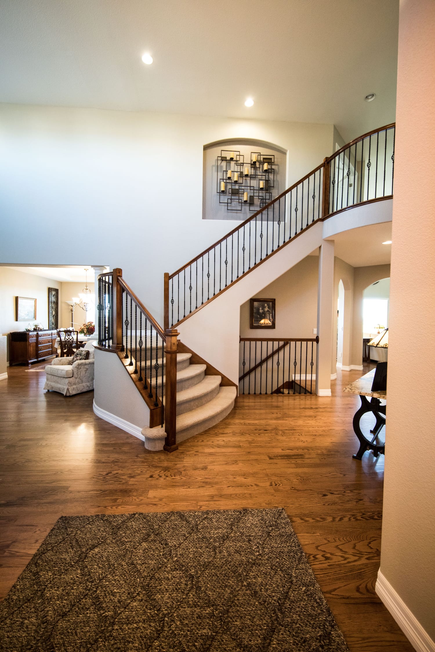 Curved wood staircase and hardwood flooring in a Las Vegas foyer